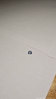 Oval cut Ceylon blue sapphire gemstone on white paper background, showing size and color.