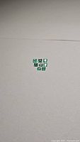 Photo showing 8 small baguette cut emerald stones arranged closely on a white background to display cut and color.