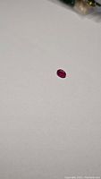 Oval cut natural red ruby gemstone, clarity enhanced, shown on white background