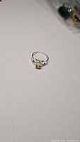 Photo of a sterling silver ring with an oval cut yellow-orange citrine gemstone set in the center.
