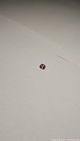 Oval yellow sapphire gemstone on white background showing natural color and facets.