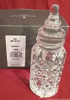 Crystal baby bottle displayed with its original box labeled '2000 Baby Bottle' with barcode and 'Made in Ireland'.