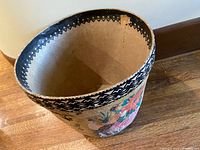 Top view of the wastebasket showing the inside rim and the small tear present on the upper edge.