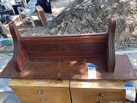Shelf placed upside down showing the bottom and applique carving along back panel and side supports.