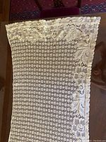 Top section of one lace curtain showcasing floral leaf pattern