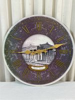 Front view of the round wall clock showing the whole face, Roman numerals, gold clock hands and Italian architectural image in center.