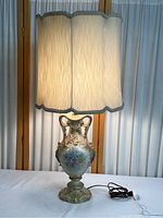 Full view of lamp assembled with illuminated shade, showing the height and overall look with lamp plugged in.