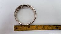 Top-down photo showing the bangle bracelet next to a ruler for size reference measuring approximately 2.5 inches in diameter.