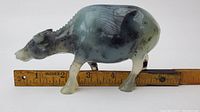 Side profile of the jade water buffalo figurine showing stone color and texture with ruler for scale indicating about 5.5 inches length.