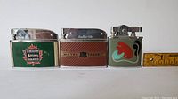 Front view of the three collectible lighters showing branding and design details