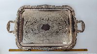 Full front view of rectangular silverplate tray with handles and decorative border showing overall condition and size with ruler.