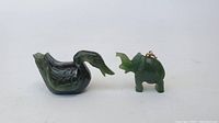 Front view of the two jade carvings: duck figurine on left, elephant on right with metal ring