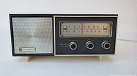 Front view of vintage Panasonic radio showing speaker, tuning scale, and control knobs.