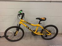 Side view of yellow Opus children's bicycle showing 17 inch wheels and frame branding.