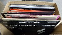 Box of various vinyl LP records, visible front record is Gilles Vigneault in stereo Columbia sleeve.