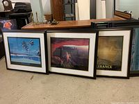 Three framed inspirational prints leaning against table with labels Success, Vision, Perseverance.