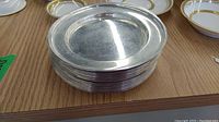 Stack of 12 round plates with smooth rim, silver finish