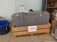 Wooden crate holding a large grey hard plastic case for a trade show booth.