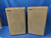 Front view of two rectangular vintage Videoton speakers with wooden cabinets and woven grille covers, showing condition and branding.