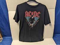 Full view of black vintage AC/DC T-shirt showing front graphic and overall condition.
