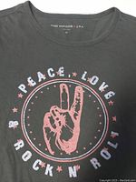 Close-up front graphic showing peace sign hand, 'PEACE, LOVE ROCK N' ROLL' text.