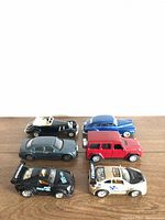 Top, front and side view of six diecast cars in mixed styles and colors on wooden surface.