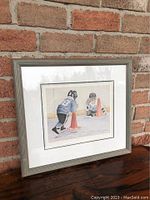 Framed print "Rookie Camp" by John Newby showing two youth hockey players on ice practicing around orange cones.