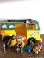 Full view of 1989 Party Wagon vehicle, large Donatello action figure, small yellow Michelangelo figure, and two Mighty Beanz figures.