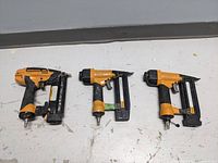 Lot of three Bostitch air nailers placed side by side showing overall external condition and size.