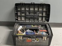 Black and Decker toolbox open showing top tray with assorted hand tools including pliers, locking pliers, and various small tools and parts.