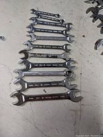 Top view of 11 Gray metric wrenches lined up by size on a surface.