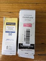 Neutrogena Sheer Zinc Visage SPF 50 sunscreen lotion and Neutrogena Moisture Oil-Free lotion boxes with visible packaging wear.