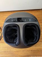 Top view of the foot massager showing the fabric-lined foot slots and the control panel with buttons for time, knead intensity, power, air intensity, and heat.
