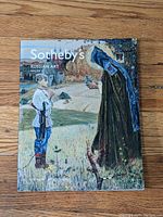 Front cover of Sotheby's Russian Art Volume II auction catalog showing a painting of a young man and a cloaked figure outside near a tree and rustic buildings.