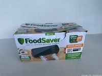 Damaged original box for FoodSaver vacuum sealing system showing product image and branding.