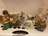 Close-up of the vintage figurines including cherub, frog, owl, unicorn and others highlighting details and colors.