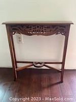 Full view of the small mahogany console table showing shape and stretcher base.