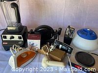 Photo of entire lot with blender, iron, waffle maker, toaster, salad spinner and black lid/tray