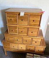 Front view showing three stacked sections with fifteen small drawers and overall finish