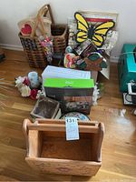 Full assortment of butterfly decor items including framed prints, wooden magazine rack, woven baskets, napkins, table decor, and other small decorative items arranged on a wooden floor.