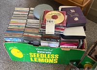 Box of CDs from various genres in a green 'Seedless Lemons' cardboard box.