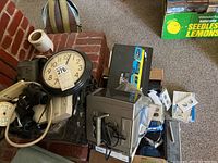 Wide view showing various small electronics including a black framed wall clock by Ingraham, surge protectors, and additional boxes including a Ring Video Doorbell.