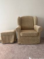Front view of the light brown arm chair and ottoman, showing upholstery and overall condition.