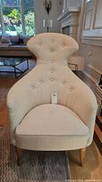 Front view of beige Van Gogh style occasional chair placed indoors on a rug with wooden floor background.