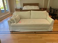 Front view of white slipcovered sofa in living space