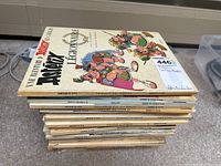 Stack of French Asterix comic books, showing multiple book spines and some cover art.