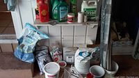 Various gardening items arranged on a shelf including bags of soil amendments and twine.