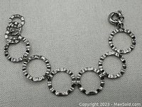 Close-up image of Birks silver 925 bracelet showing round hammered design links and spring ring clasp with three smaller adjustable links.