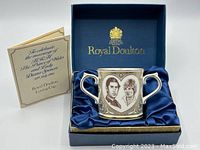 Photo of the loving cup inside the original blue satin-lined Royal Doulton box, along with the informational booklet.