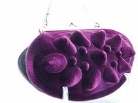 Close-up front view of purple molded handbag showing raised bumps in deep purple velvet.